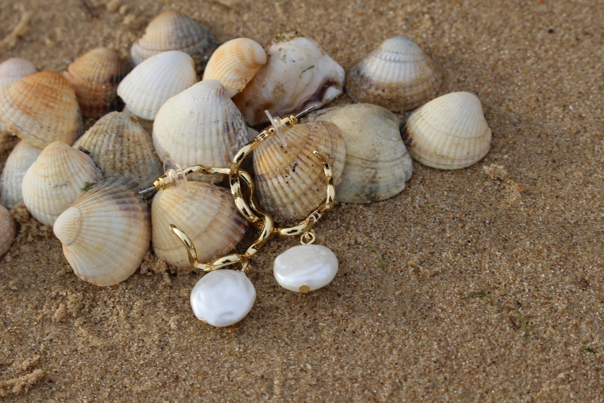 Giana natural pearl drop loop gold earrings sitting on seashells